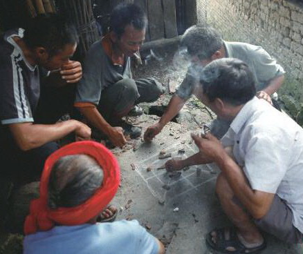 陰雨天,三五瑤民聚在一起玩瑤族傳統(tǒng)“趕豬棋”。